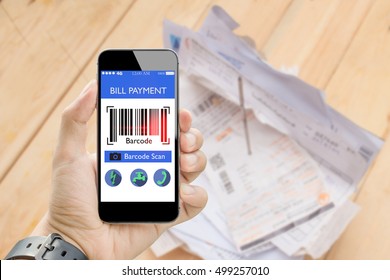 Man Holding Smart Phone Online Bill Payment With Bar Code Scan With Blurred Utilities Bill On Wooden Table In Background,fake Barcode