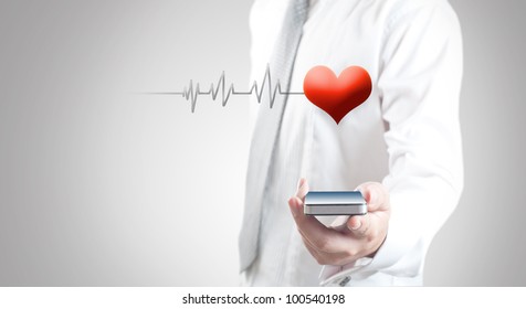 Man Holding Smart Phone Showing Red Heart And Pulse