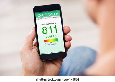 Man Holding Smart Phone Showing Credit Score Application On A Screen - Shutterstock ID 566473861