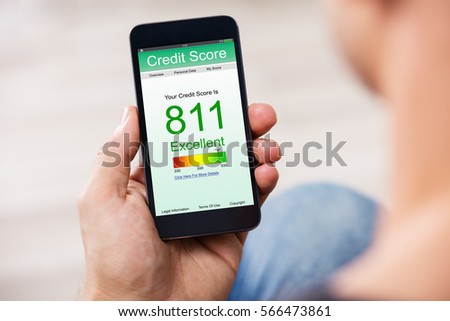 Man Holding Smart Phone Showing Credit Score Application On A Screen