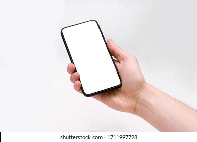 Man holding smartphone with blank screen on white background, closeup of hand. Space for text - Shutterstock ID 1711997728