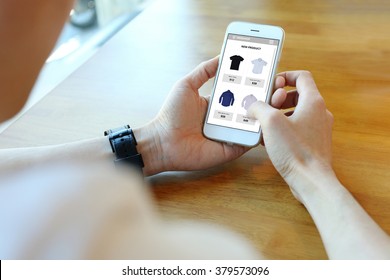 Man holding smartphone with choose shirt on ecommerce website