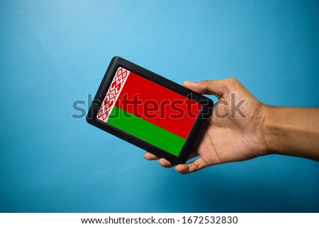 Man holding Smartphone with Flag of Belarus. Belarus Flag on Mobile Screen isolated On Blue Background