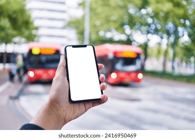 Man holding smartphone showing white blank screen at bus stop - Powered by Shutterstock