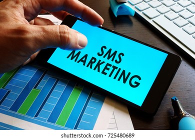 Man Holding Smartphone With Words Sms Marketing.