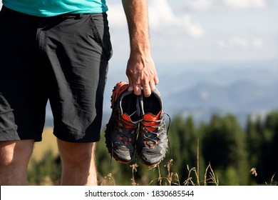 Man Holding Sneakers On The Mountains