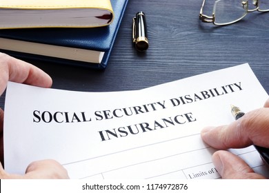 Man Is Holding Social Security Disability Insurance SSDI Policy.