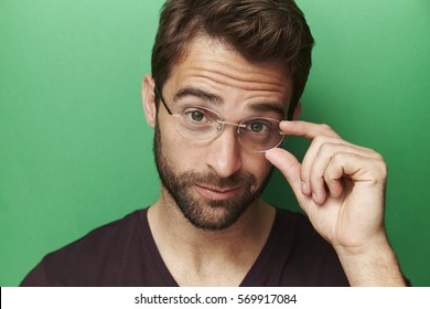 Man holding spectacles in studio, portrait