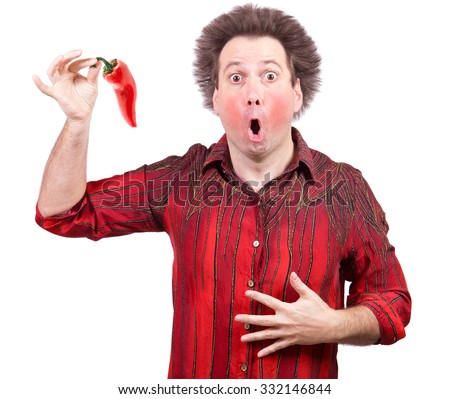 Man holding a spicy red paprika isolated on white background. The shock of hot chili peppers. Red face from eating hot vegetable. 