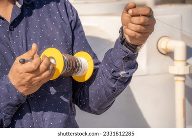 man holding spool charkhi of string with glass covering showing fighting kites flown on sankranti uttarayan independence day in Delhi