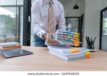 Man Holding Stack of Documents with Color Tabs