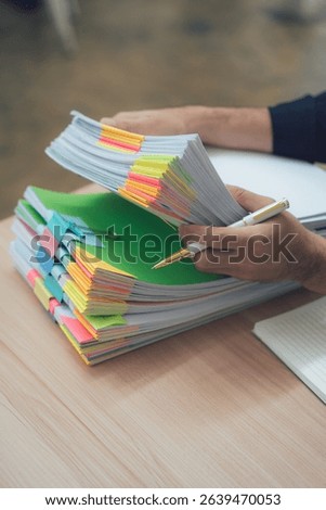 Man Holding Stack of Documents with Color-Coded Tabs