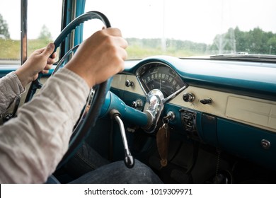 Man Holding The Steering Wheel Of An Old Car With The Dashboard In View