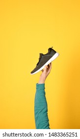 Man Holding Stylish Shoe On Yellow Background, Closeup