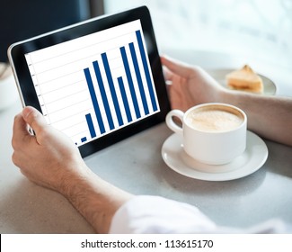 Man Holding Tablet Computer With Graphic In Cafe