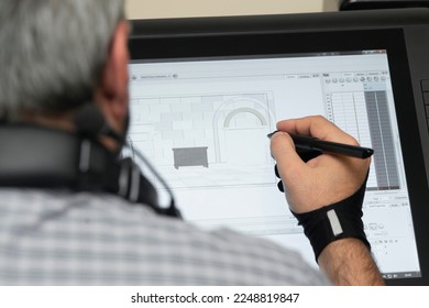 man holding a tablet and drawing with a pen in his hand