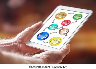 Man holding a tablet showing data transfer concept - Shutterstock ID 1522032479