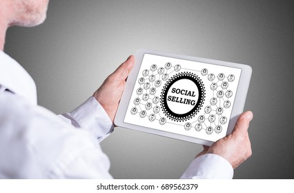 Man Holding A Tablet Showing Social Selling Concept