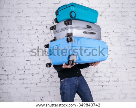 Man holding three heavy suitcases in hand. Travel light. Foto d'archivio © 