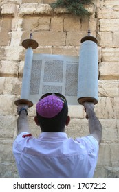 A Man Holding A Torah Scroll At The Western Wall