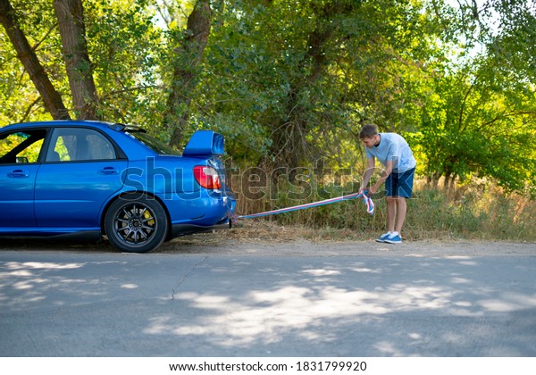 man holding a towing\
rope and install it on the car hook, the auto accident and problem\
with engine
