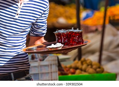 Man Holding Tray Containing Glasses Of Tea