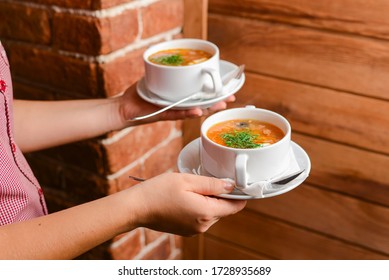 Man Holding Two Bowls Of Soup. Waiter Serving Fresh Hot Soup In A Diner Or Restaurant. Healthy Delicious Dinner. Waiter At Work. Restaurant Service.