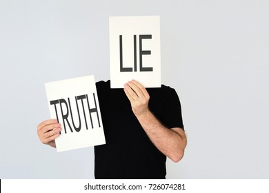 Man holding two cards with the words Lie and Truth representing different falsehood. Duality concept.