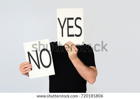 Man holding two cards with the words YES and NO representing different options. Duality concept.