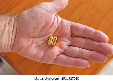 Man Holding Two Ounce Nuggets Of  Gold Bullion