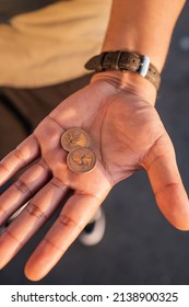 Man Holding Two Quarters On His Hand