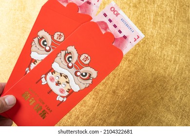 man holding two red pockets for the year of tiger 2022 translation of the Chinese to English-happy new year no logo no trademark