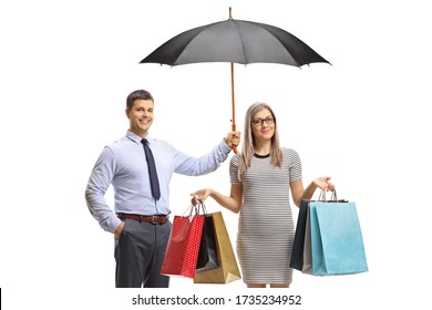 Man Holding An Umbrella Over A Young Woman With Shopping Bags Isolated On White Background