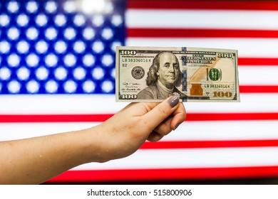 Man holding US Dollar bank note indicating market crash due to new US president with flag background