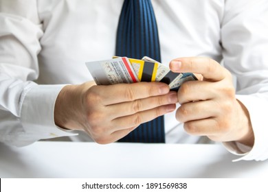 Man Holding Various Credit Cards In His Hand In Front Of A White Background. Credit Card Usage. Conscious Consumers. Consumer Shopping Habits.