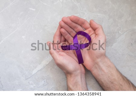 Man holding violet cancer ribbon, symbol of pancreatic. Concept of health and medicine. 