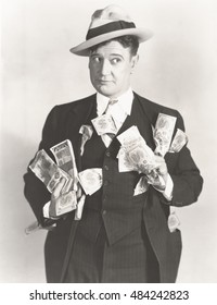 Man holding wads of fake money
