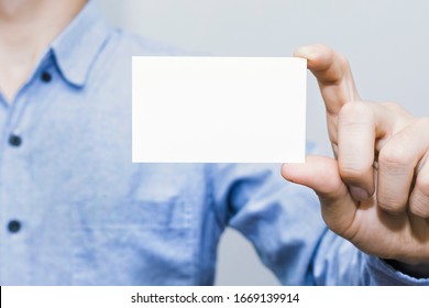 Man Holding White Business Card On Concrete Wall Background,mockup Template