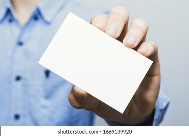 Man Holding White Business Card On Concrete Wall Background,mockup Template