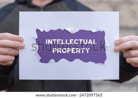 Man holding white and violet sheets of paper with inscription: INTELLECTUAL PROPERTY. Intellectual Property Rights, Copyright, Patent or Trademark Infringement.