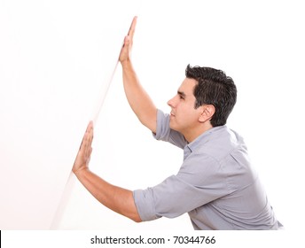Man holding a white wall over white background