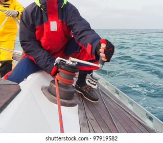 Man Holding Winch With Rope On Sailing Boat