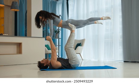 Man holding woman exercise trust together husband wife sport flexibility aerobics gymnastics active strong yoga balance health acroyoga acrobatic fitness pilates pose lifting female male training fly - Powered by Shutterstock