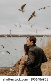 Man Holding Woman Watching Flock Of Birds Flying In Sky Over River Support Of Husband Family Relatives During Virus Quarantine. Healing Of Mental Health By Walks Outdoor