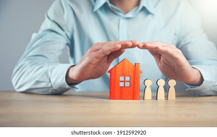 man holding wood family with house. Insurance and property investment real estate concept