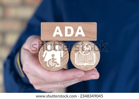 Man holding wooden blocks with icons and abbreviation: ADA. Concept of ADA Americans with Disabilities Act.