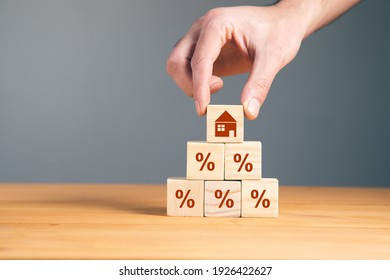 man holding wooden blocks with percent and house