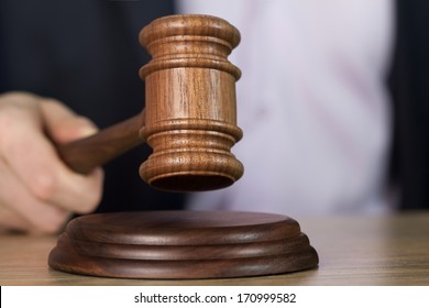 Man holding wooden gavel in the hand 