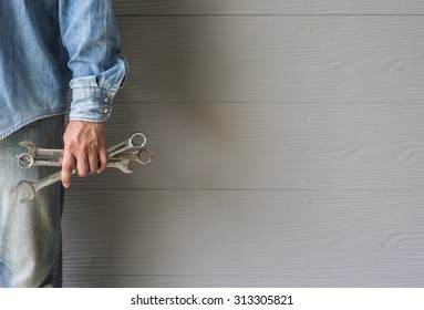 Man holding wrench tool on grey background