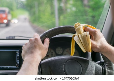 A Man Holds A Banana In His Hand, A Healthy Snack On The Way